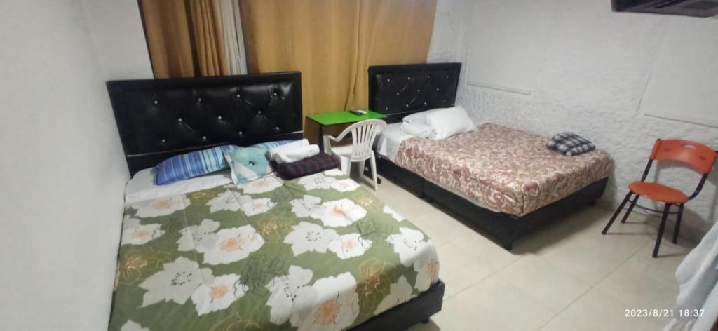 波哥大Hotel Palma de la Sabana的一间卧室配有两张床和两把椅子