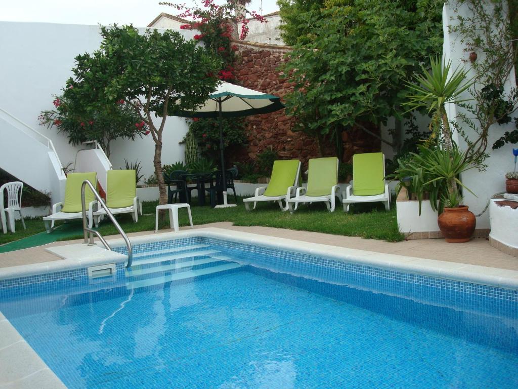 西尔韦斯卡萨克劳迪娅泳池及Wifi公寓的游泳池旁设有绿色和白色椅子