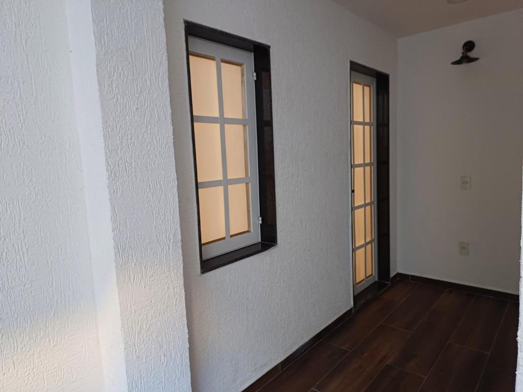 里约热内卢Loft em Olaria的一间空房间,设有2扇窗户和木地板