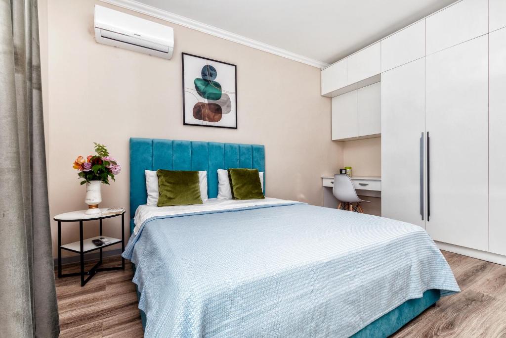 阿斯塔纳Новая квартира в самом центре города的一间卧室配有一张大床和蓝色床头板