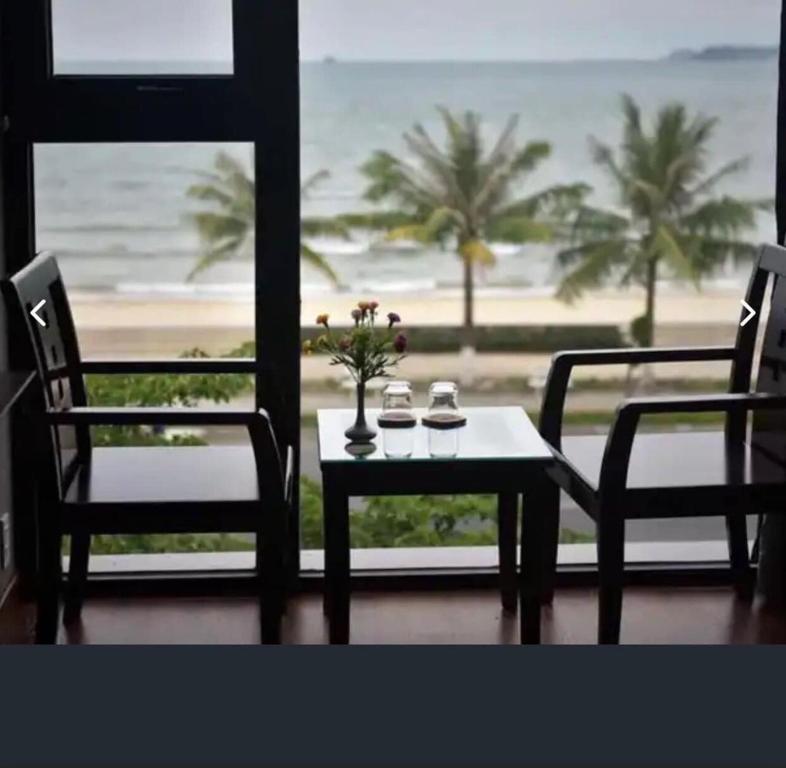 岘港Holiday Inn Hotel的一张桌子和椅子,享有海滩美景