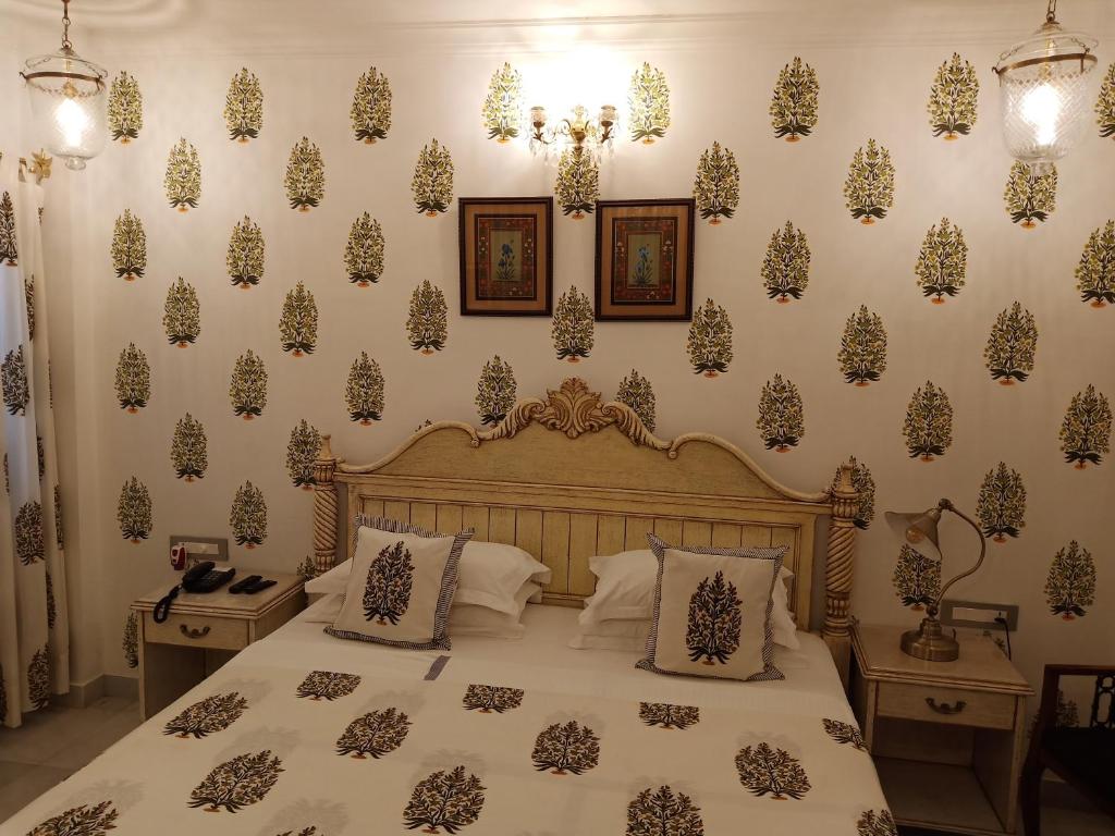 乌代浦杰加特尼瓦斯宫殿酒店的一间卧室配有床和壁纸覆盖的墙壁