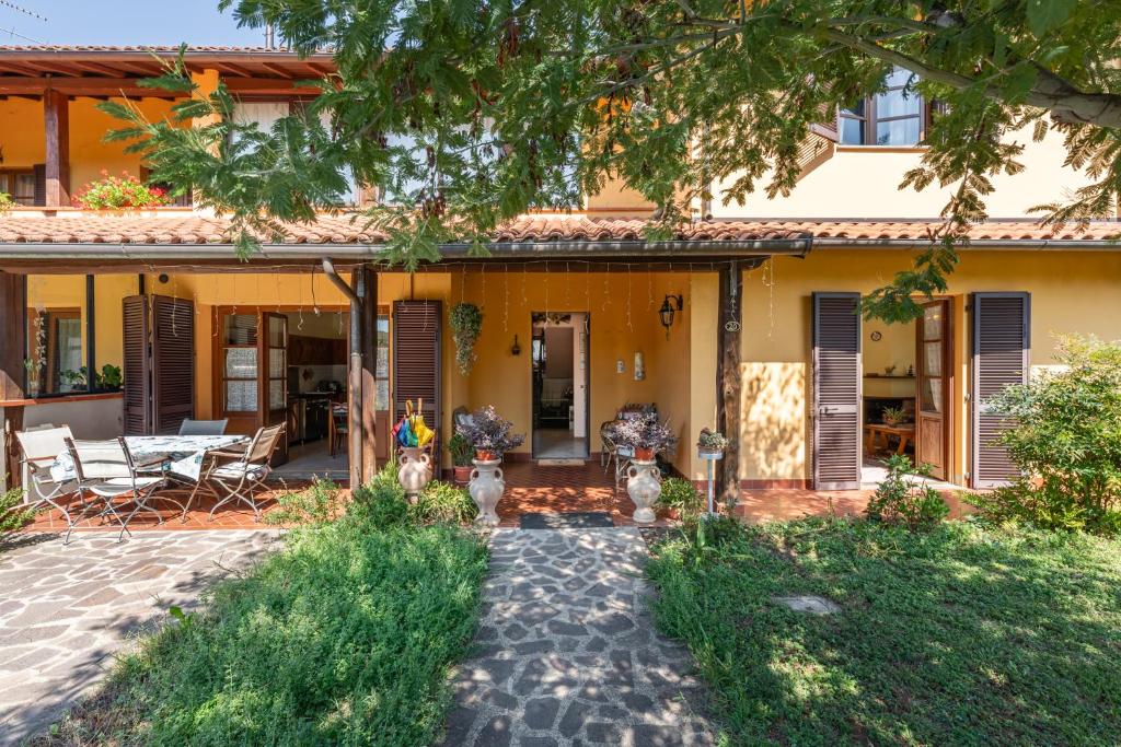 皮耶韦福斯切纳Casa di Nonna Adriana的黄色的房子,前面设有一个庭院