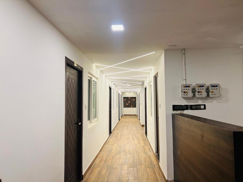 马杜赖David Residency的长长的走廊,设有白色的墙壁和木地板