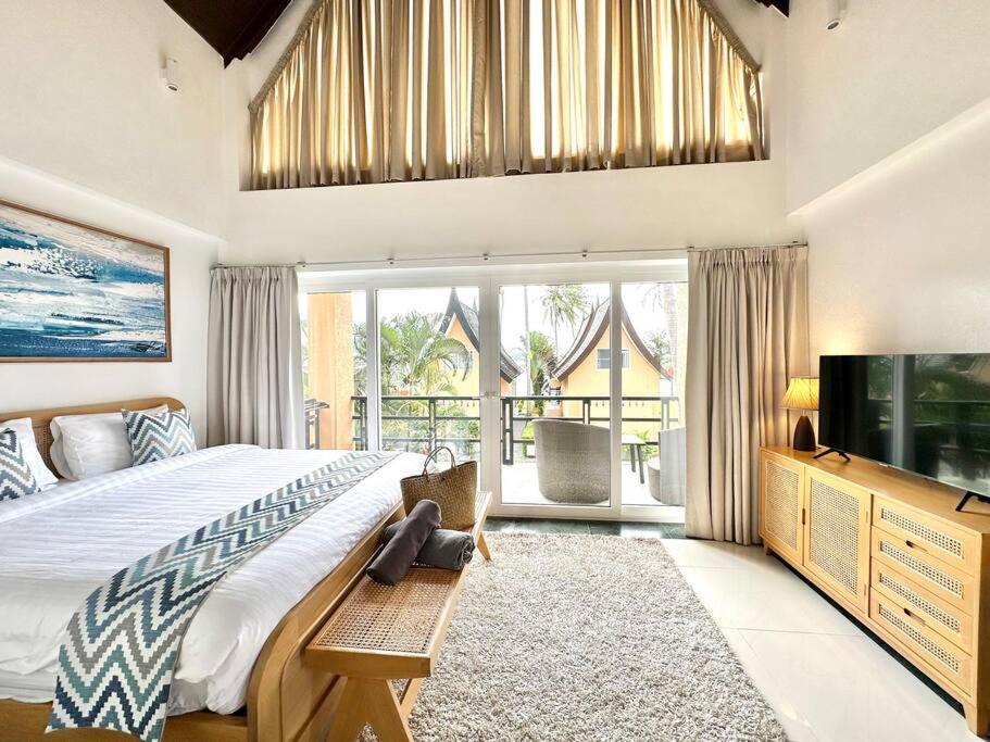 象岛Sunrise Beach Villa的一间卧室配有一张大床和电视
