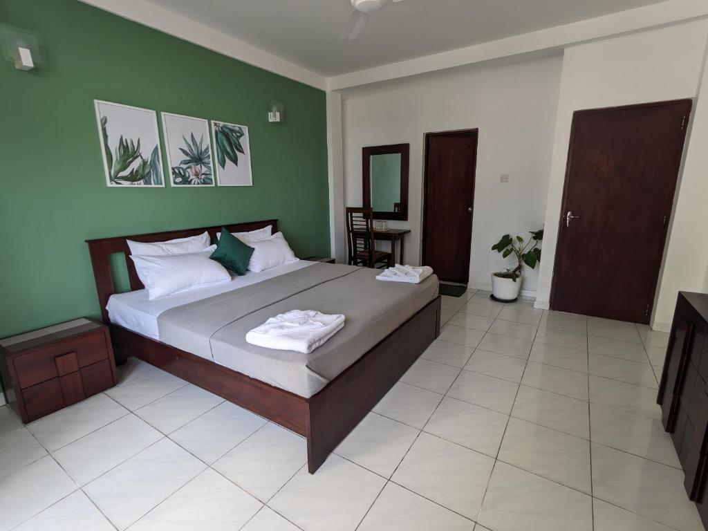 科伦坡帕尔米拉住宅酒店的一间卧室设有一张带绿色墙壁的大床