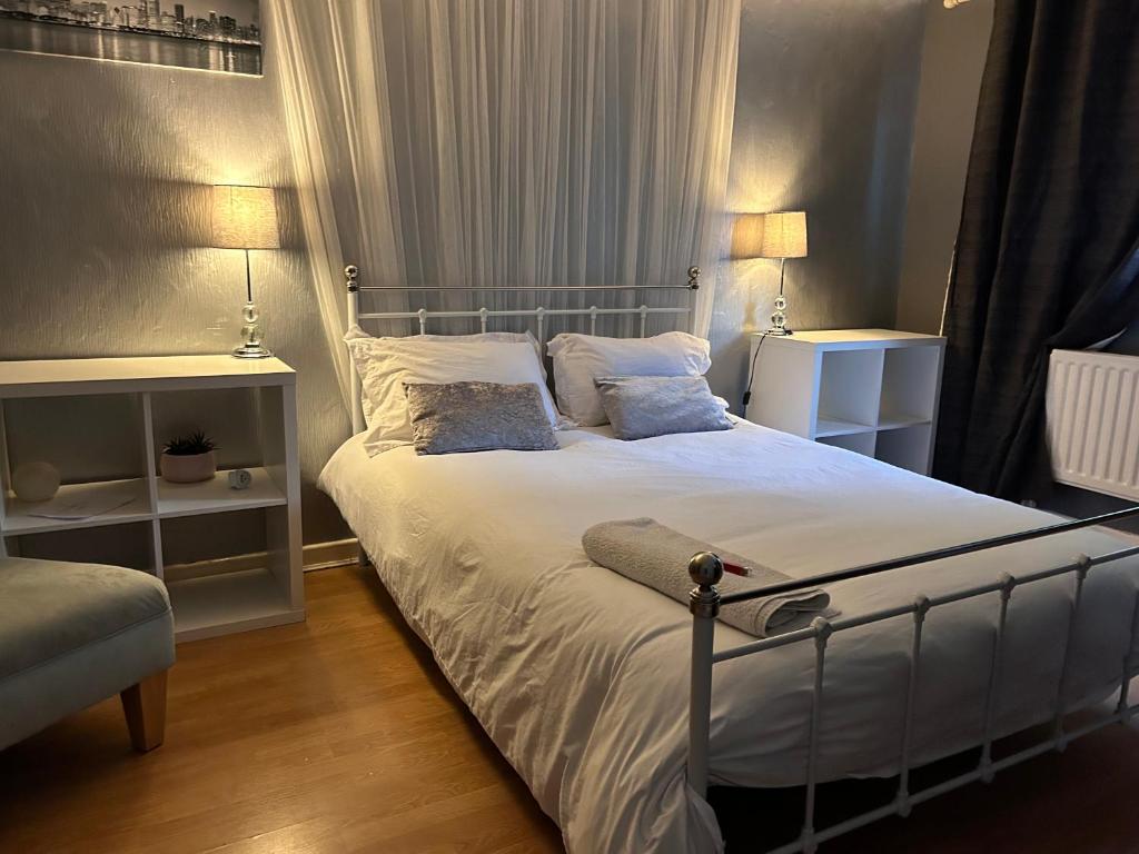 雷迪奇Home from home, close to Redditch hospital & transport links的一间卧室配有带白色床单和枕头的床。