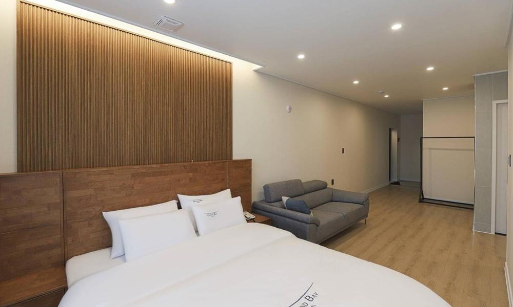 保宁市Hotel Grand Bay Boryeong的一间卧室配有一张床、一把椅子和一张沙发