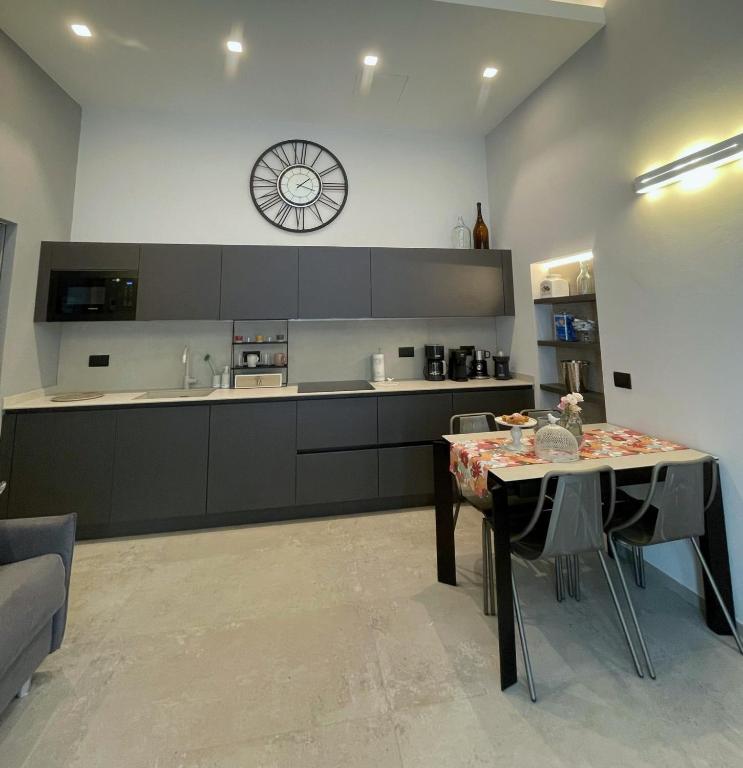 科莫Civico29 appartamento bilocale的厨房配有桌子和墙上的时钟