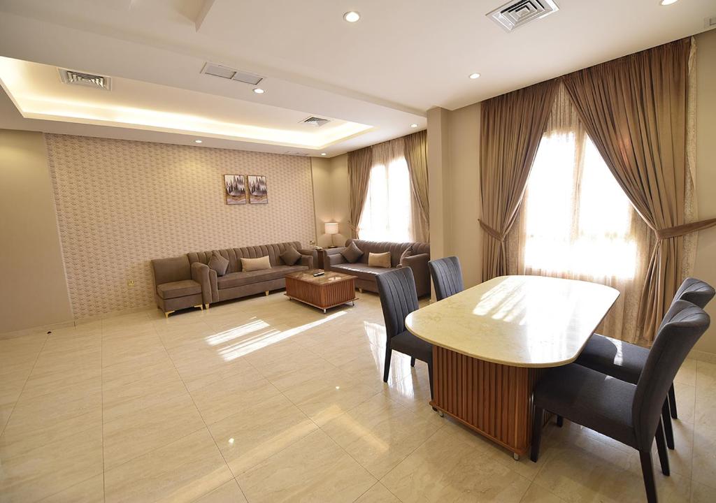 科威特الدرة للشقق الفندقية的客厅配有桌椅和沙发