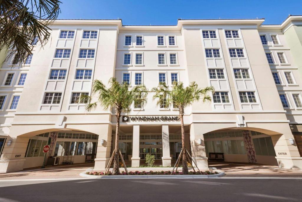 朱庇特朱庇特滨港广场温德姆格兰德酒店的一座白色的大建筑,前面有棕榈树
