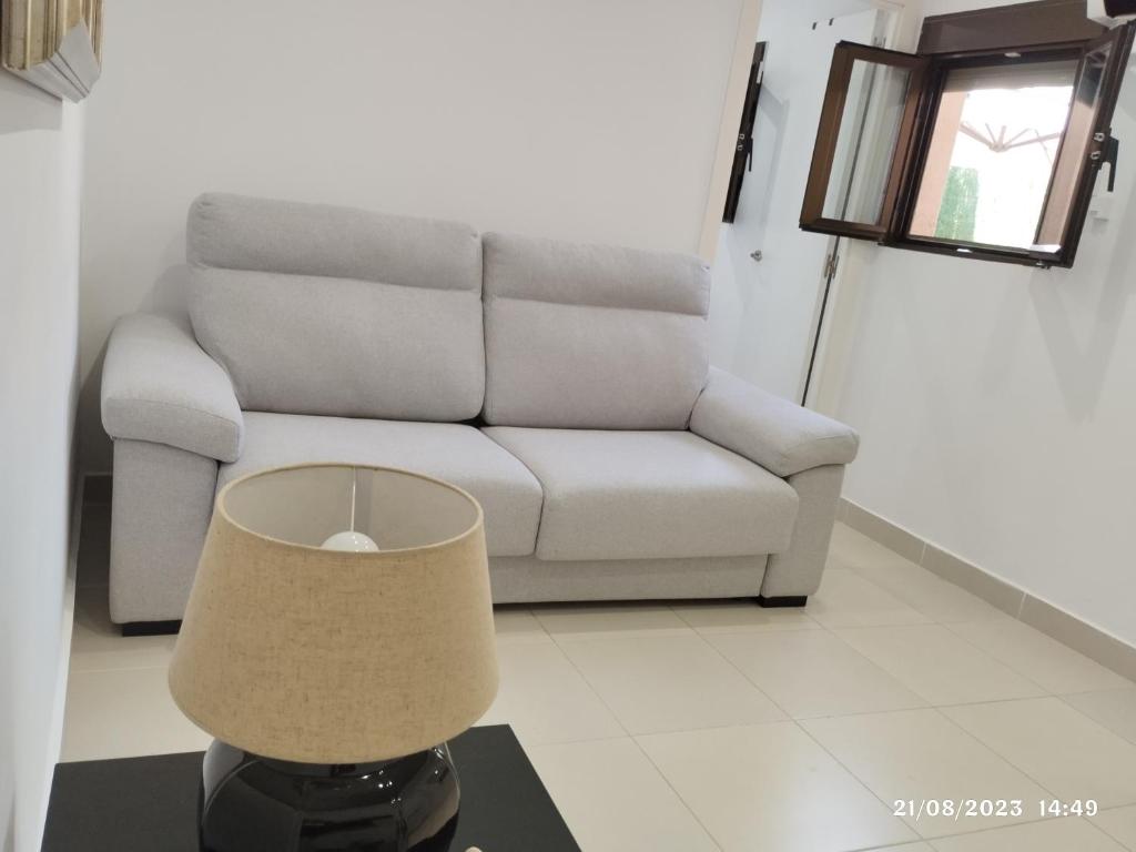 马德里Apartamento Agradable1的客厅配有沙发和带台灯的桌子
