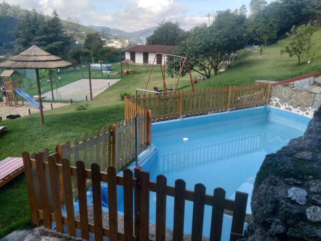布拉加Quinta dos Campos - Apartamento 2的一个带木栅栏的游泳池和一个游乐场