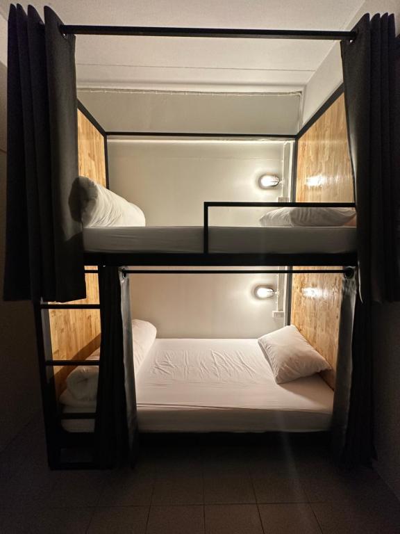 涛岛Sleep tight hostel koh tao的客房设有带白色床单的双层床。