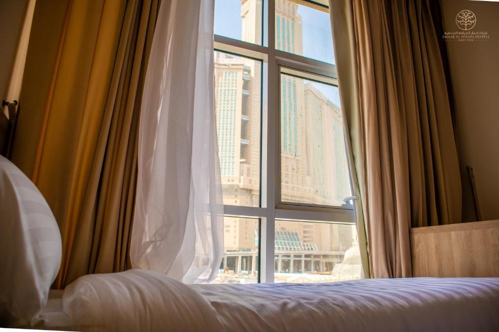 麦加Worth Elite Hotel的一间卧室设有窗户,享有城市美景