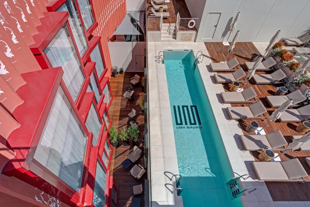 马德里UMusic Hotel Madrid的享有酒店高空的景致,设有游泳池和椅子