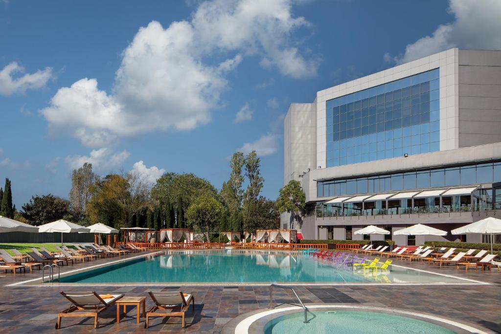 伊斯坦布尔伊斯坦布尔阿塔科尤喜来登酒店的一座带躺椅的游泳池和一座建筑