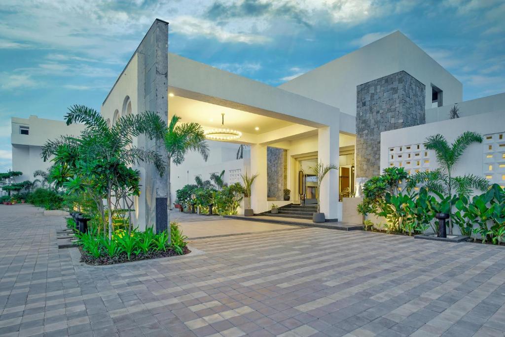 戈巴尔布尔Pramod Lands End Resort, a member of Radisson Individuals的一座白色的大建筑,庭院里种有植物
