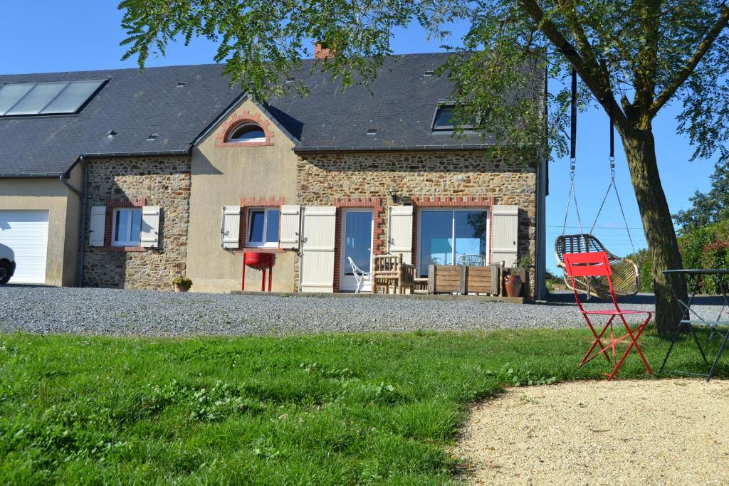 La BaconnièreGite sublime campagne的前面有红椅的房子