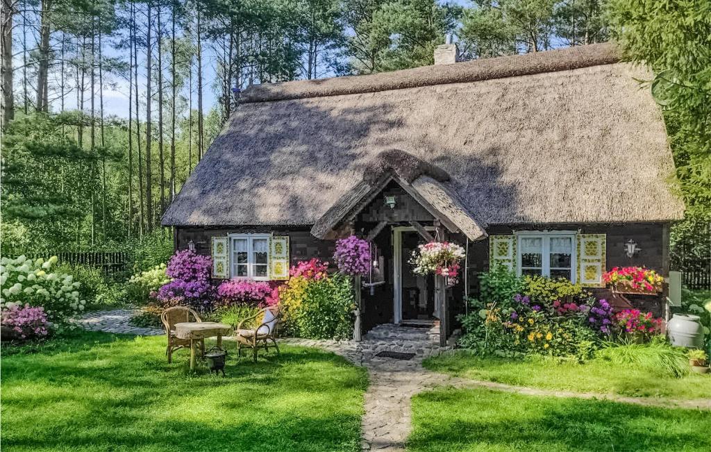 OsiekAwesome Home In Osiek With Kitchen的庭院里种满鲜花的茅草小屋