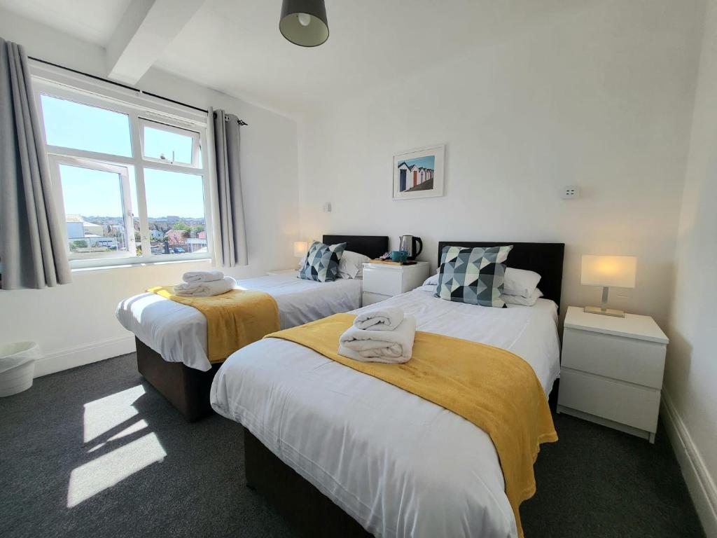 佩恩顿Beach Hotel Torbay的一间卧室设有两张床和窗户。