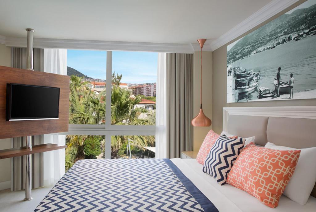 库萨达斯Paloma Marina Suites - Adult Only的一间卧室设有一张床和一个大窗户