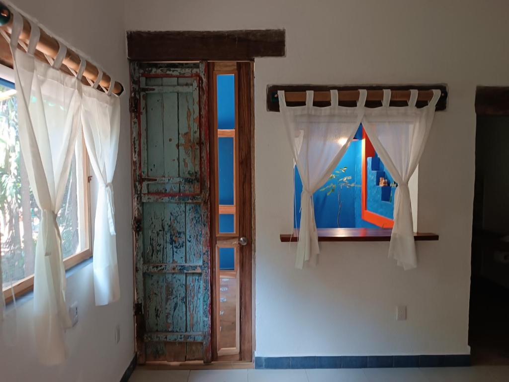 坎昆jungle lodge的配有窗帘和窗户的开放式门