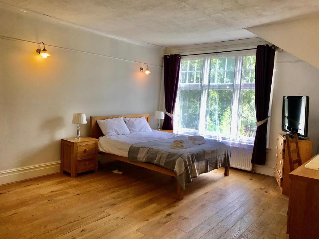 伦敦Spacious 3 Bed Room Flat in South West London的一间卧室设有一张床和一个大窗户