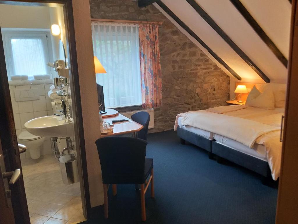 普莱滕贝格Hotel Klinger的一间卧室配有一张床、一张桌子和一个水槽