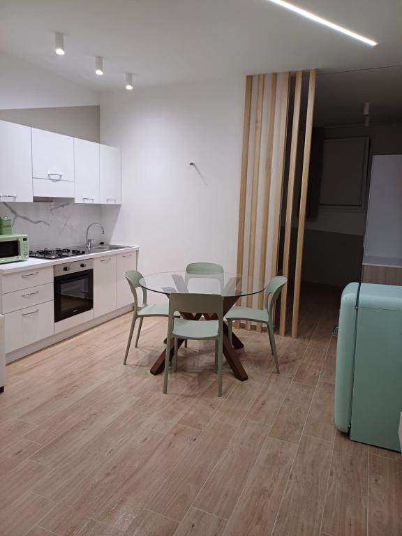 库斯托纳奇Appartamento Nonna Lina的厨房以及带桌椅的用餐室。