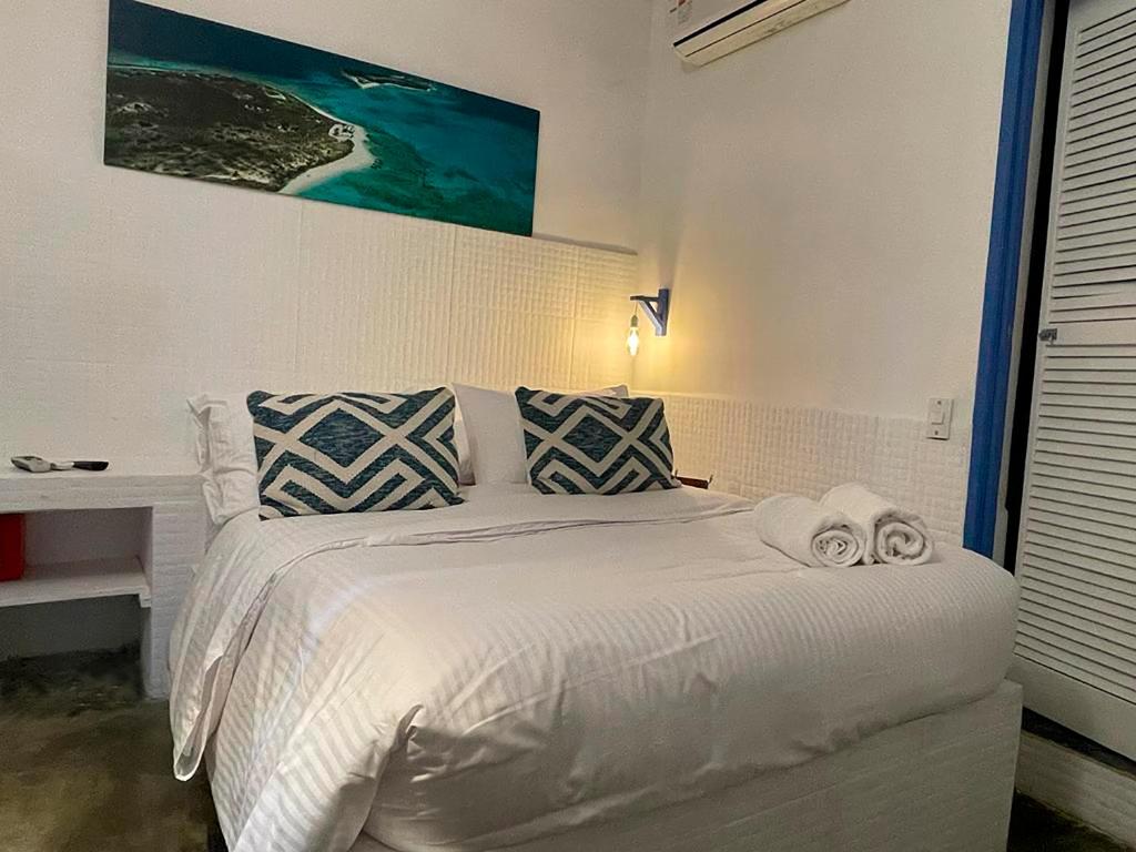 罗克斯群Posada Lagunita的卧室配有白色床和毛巾
