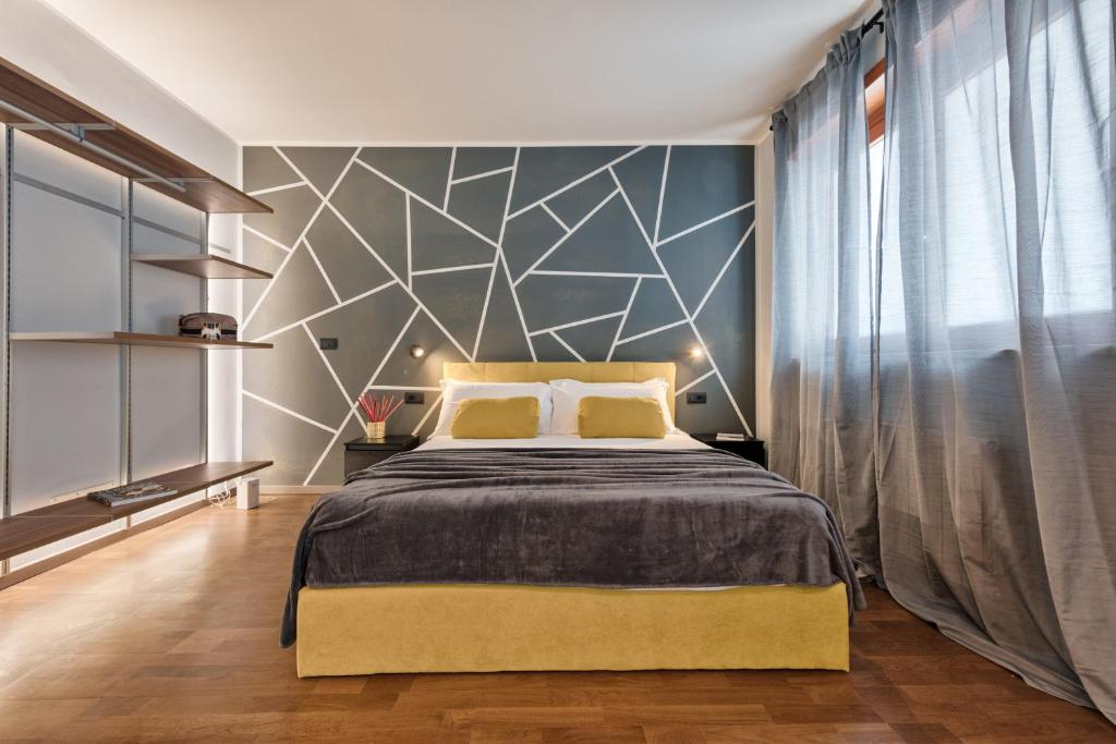 维纳利亚瑞勒Casa RIGOLA by Apartments To Art的一间卧室设有一张带几何墙的大床
