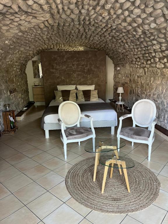 欧布纳GITE DE LA CAPPELLA - CHAMBRE D'HÔTES A VOLTA的一间卧室配有一张床、两把椅子和一张桌子