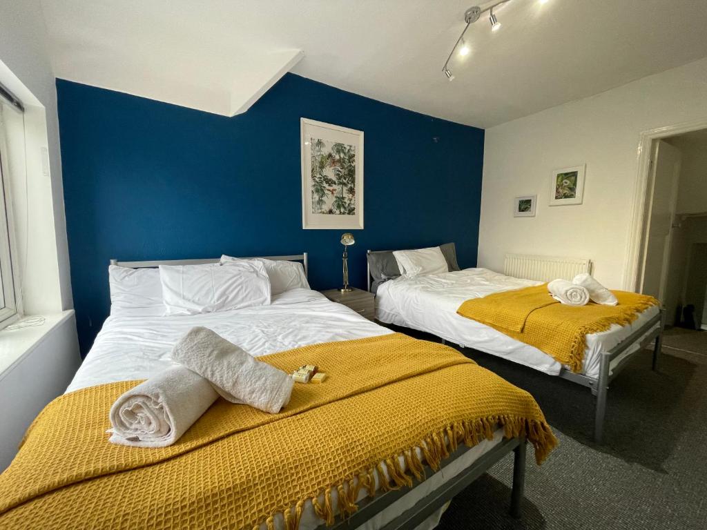 曼彻斯特HUGE Apartment - 12min to City - FREE parking - Contractor Friendly - IRWELL STAYS的蓝色墙壁客房的两张床