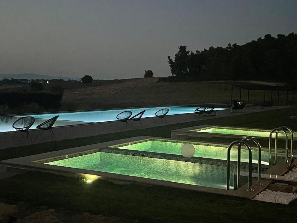 撒尼海滩Oikos Sani Suites的夜间大型游泳池,灯光照亮
