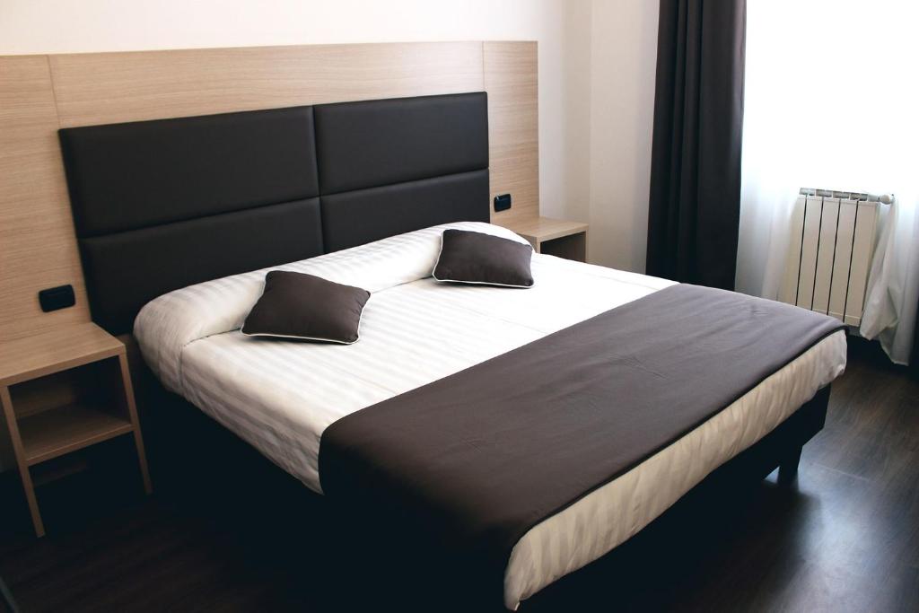佛罗伦萨埃斯佩兰萨酒店的一间卧室配有一张大床和两个枕头