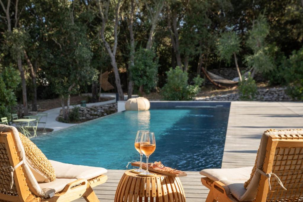 博尼法乔Aria Cigala的坐在游泳池旁的桌子上喝一杯葡萄酒