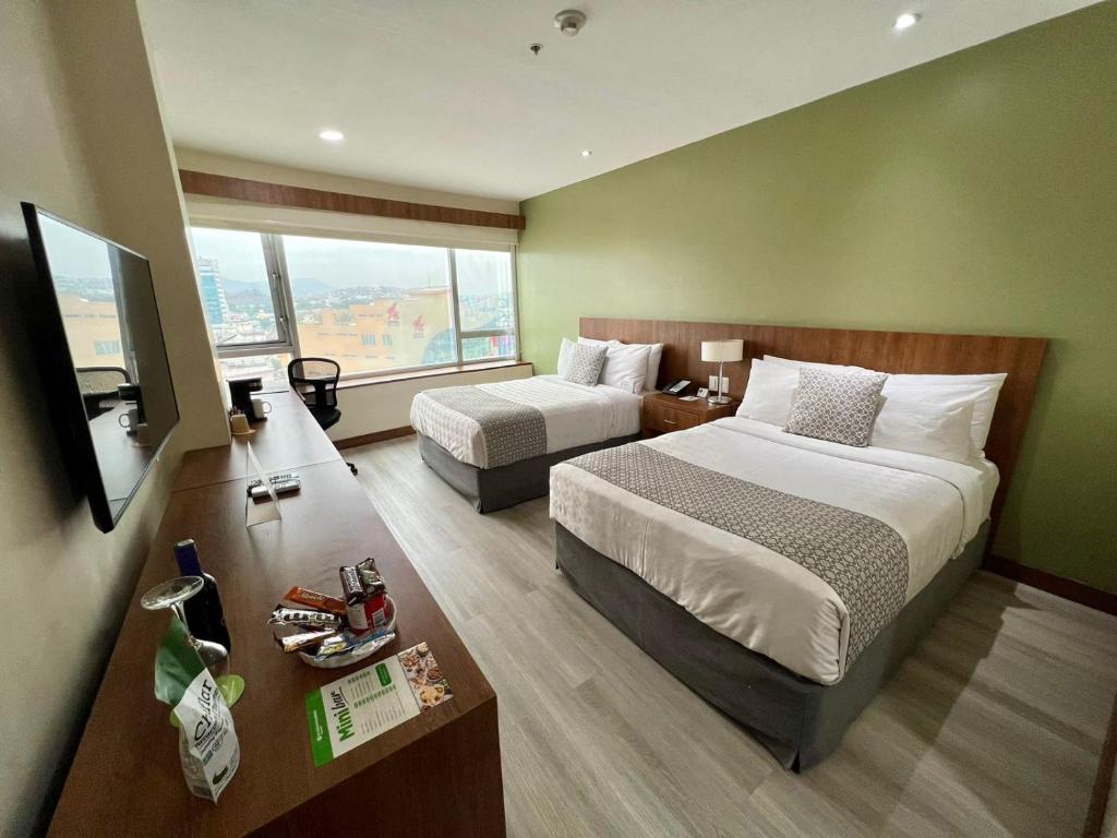 瓜亚基尔瓜亚基尔温德姆花园的酒店客房设有两张床和电视。