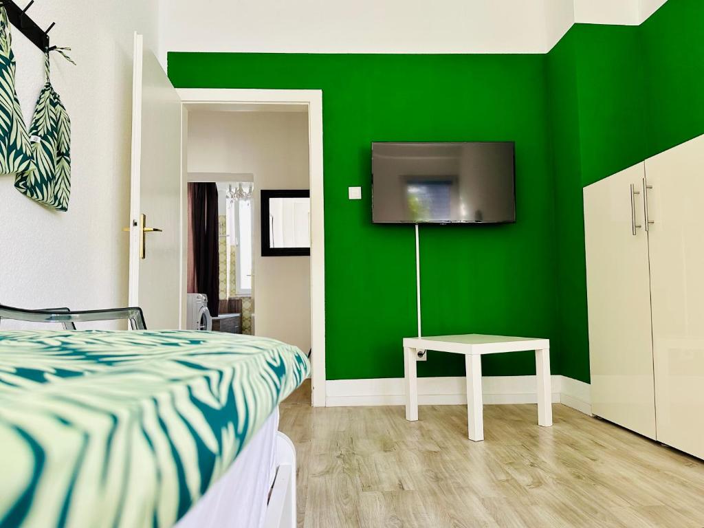哈根FeWo Ischeland near Hagen-City的一间卧室设有绿色的墙壁、一张床和一张桌子