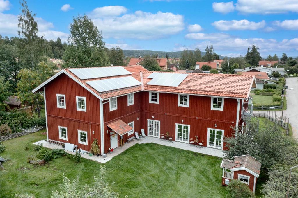 雷克桑德Flygeln的享有红色房子的空中景色,上面设有太阳能电池板