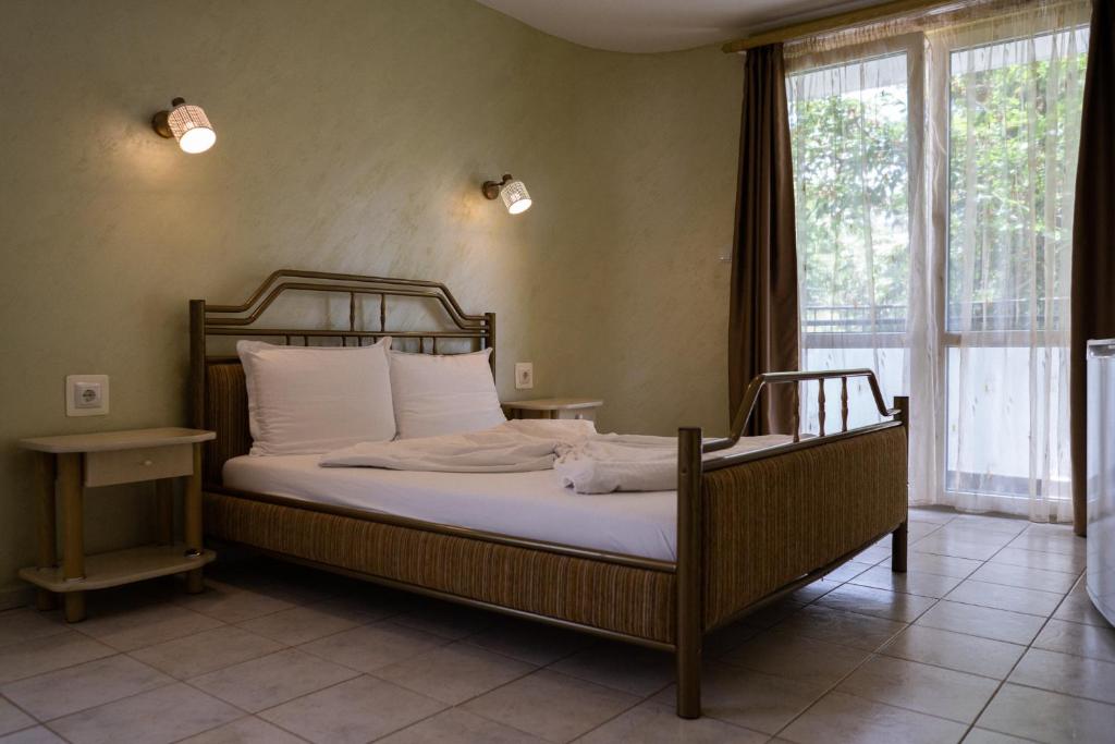鲁塞Jeweller Hotel的一间卧室配有一张带白色床单的床和一扇窗户。