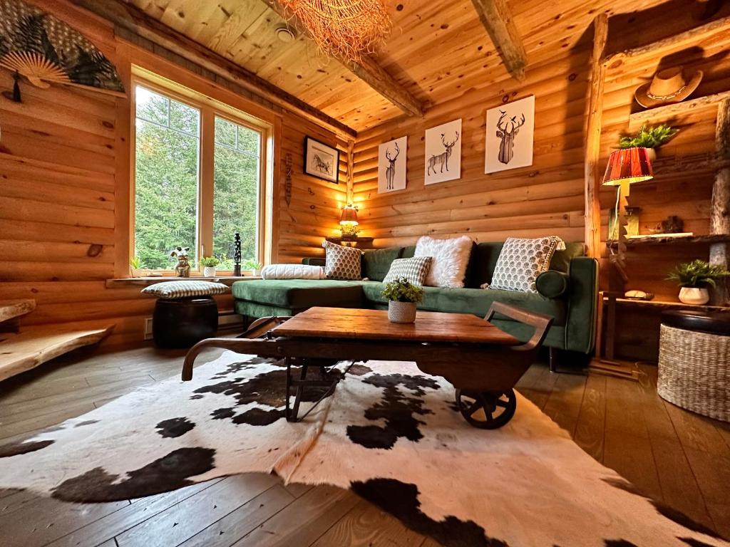 拉马巴耶Le Ti Moose - Les Chalets Spa Canada的小屋内的客厅配有沙发和桌子