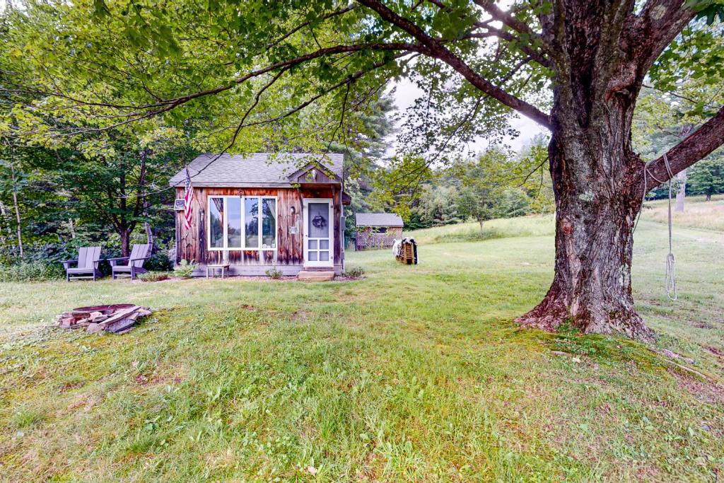 HartlandSpruce Moose Cottage的田野上的小房子,有树