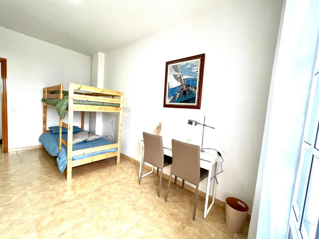 罗萨里奥港Little Home的客房设有一张桌子和一张双层床。