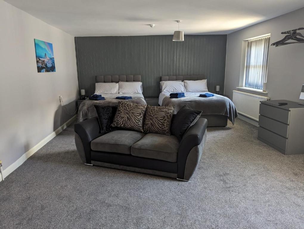 切普斯托Kings Head的一间卧室配有两张床、一张沙发和一张床。