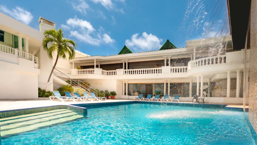 圣安德烈斯Hotel Americas San Andres Islas Colombia的房屋前的游泳池