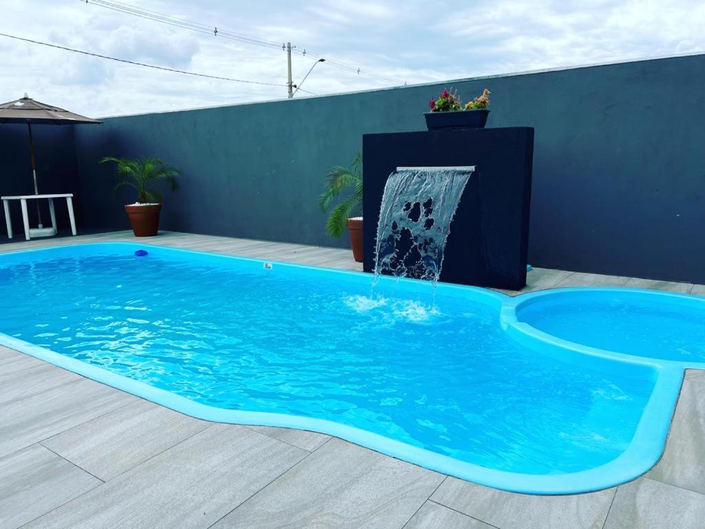 多拉杜斯JOTA Área de Lazer的一个带喷泉的大型蓝色游泳池