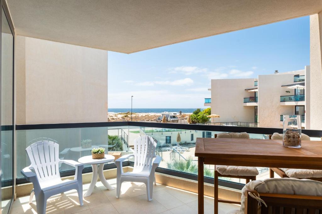 科蒂略Casa Lilia的阳台配有桌椅,享有海景。