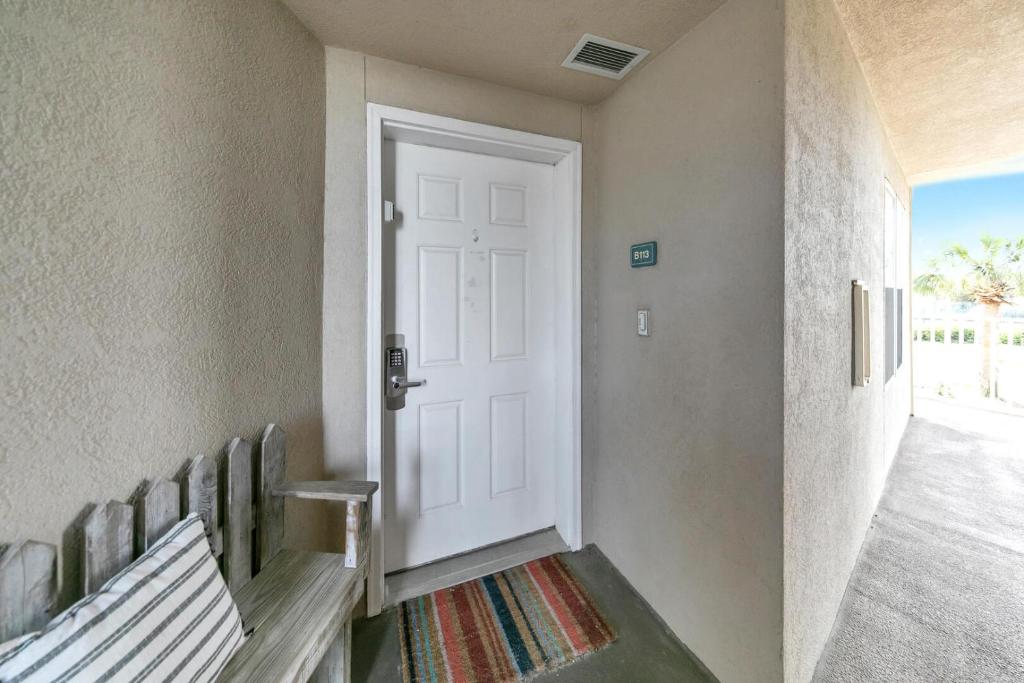 德斯坦Amalfi Coast 113B - Steps from the Beach 2BD 2BA的一条带白色门和长凳的走廊