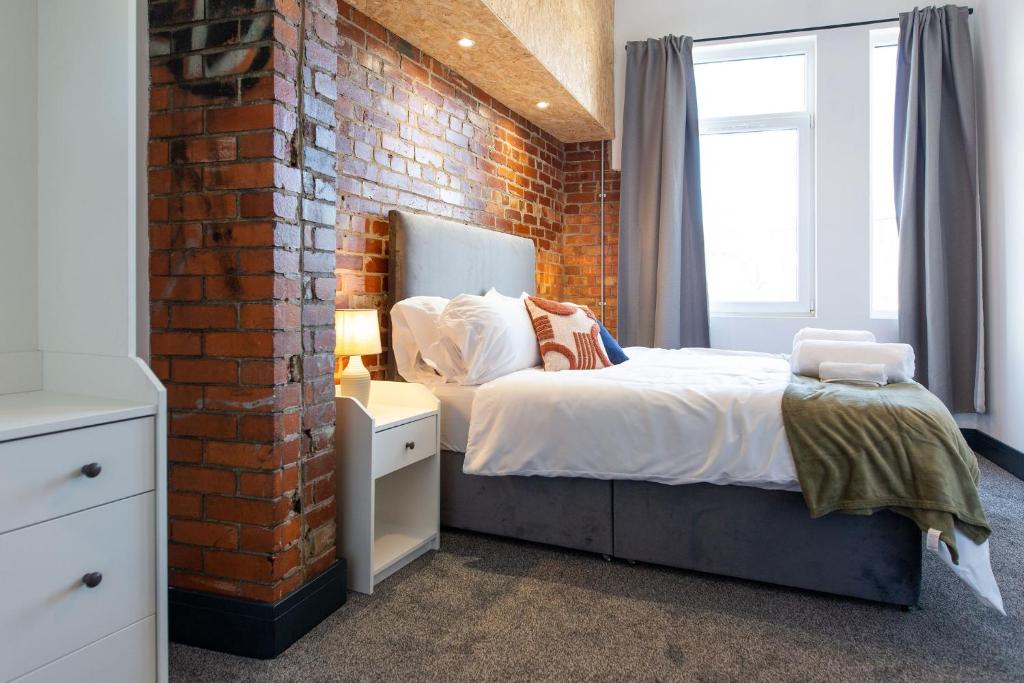 斯旺西The Kingsway- 2 Bedroom Central Swansea Apartments By StayRight的一间卧室设有砖墙和一张床